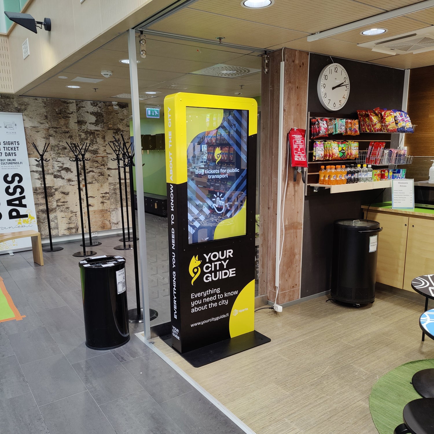 Digital kiosk with 'Your City Guide' branding in a public space.