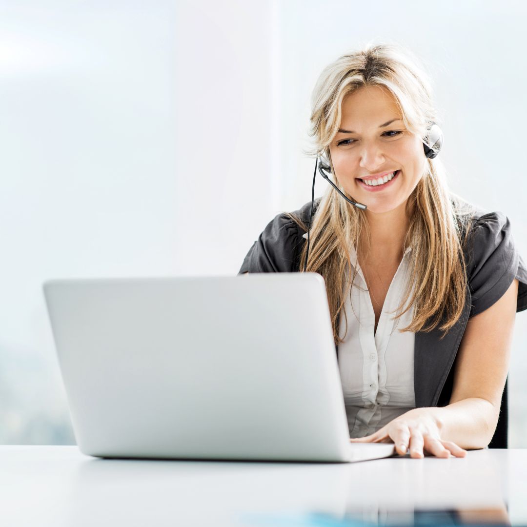 Woman with a headset using a laptop on a white background