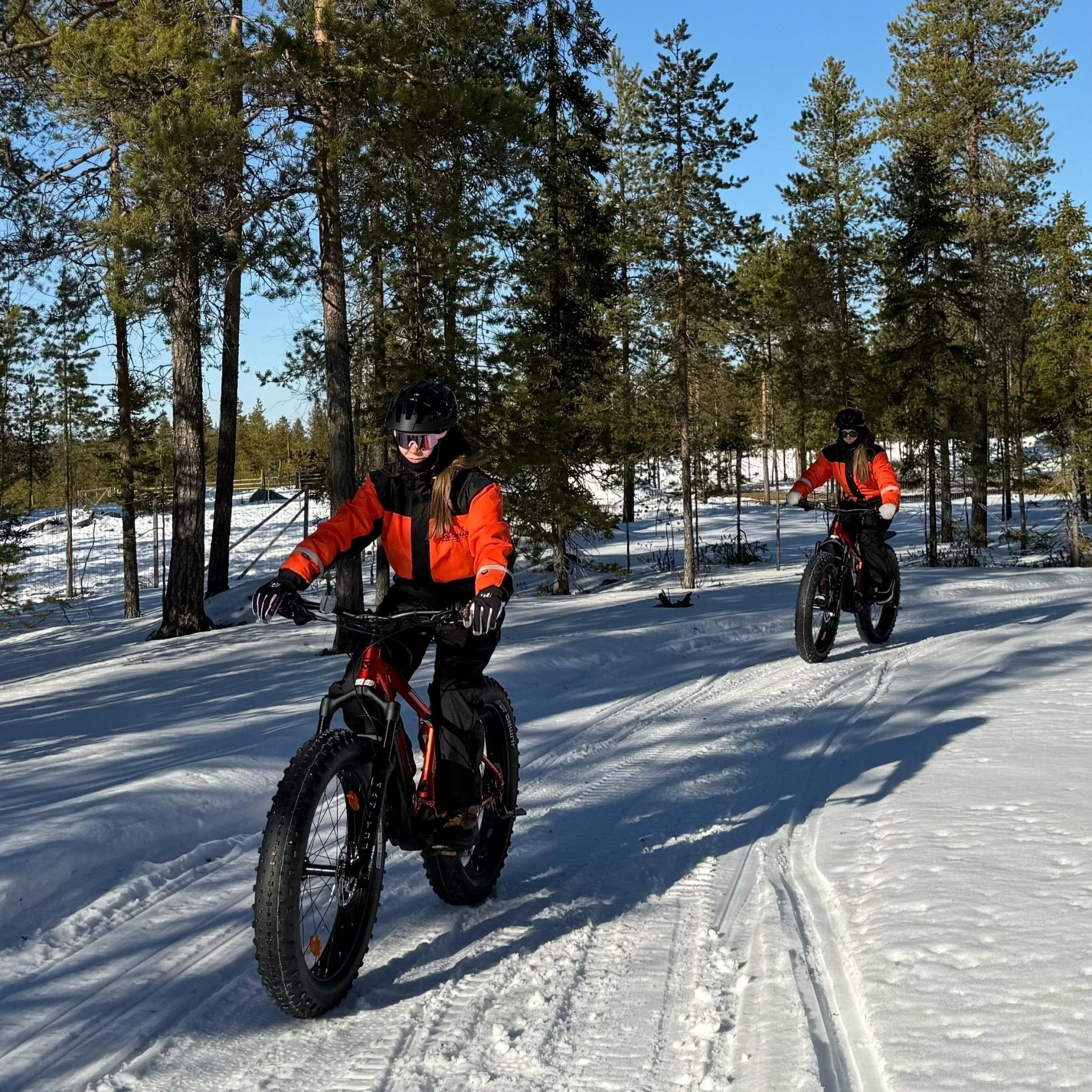 Two riders on electric fat bikes exploring snowy trails at a Reindeer Farm Electric Fat Bike Adventure Porovaara