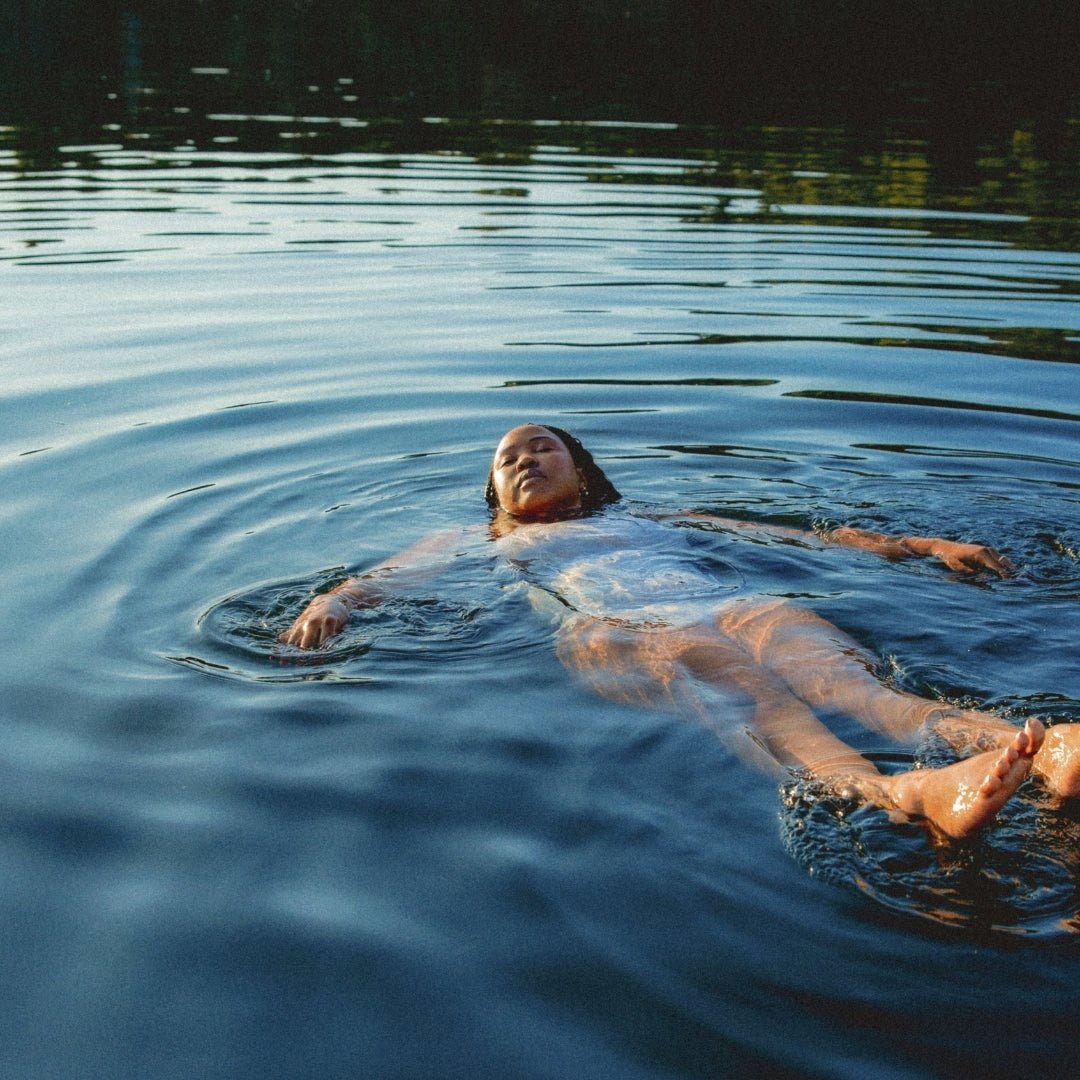 Person relaxing in Norvajärvi Lake after sauna experience titled Experience summer finnish sauna and lake by Lapin Väki