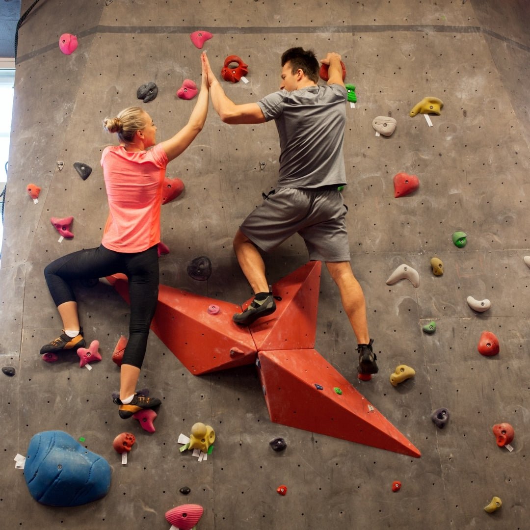 Two climbers giving high five on indoor climbing wall during Guided Climbing Experience by Lapin Väki