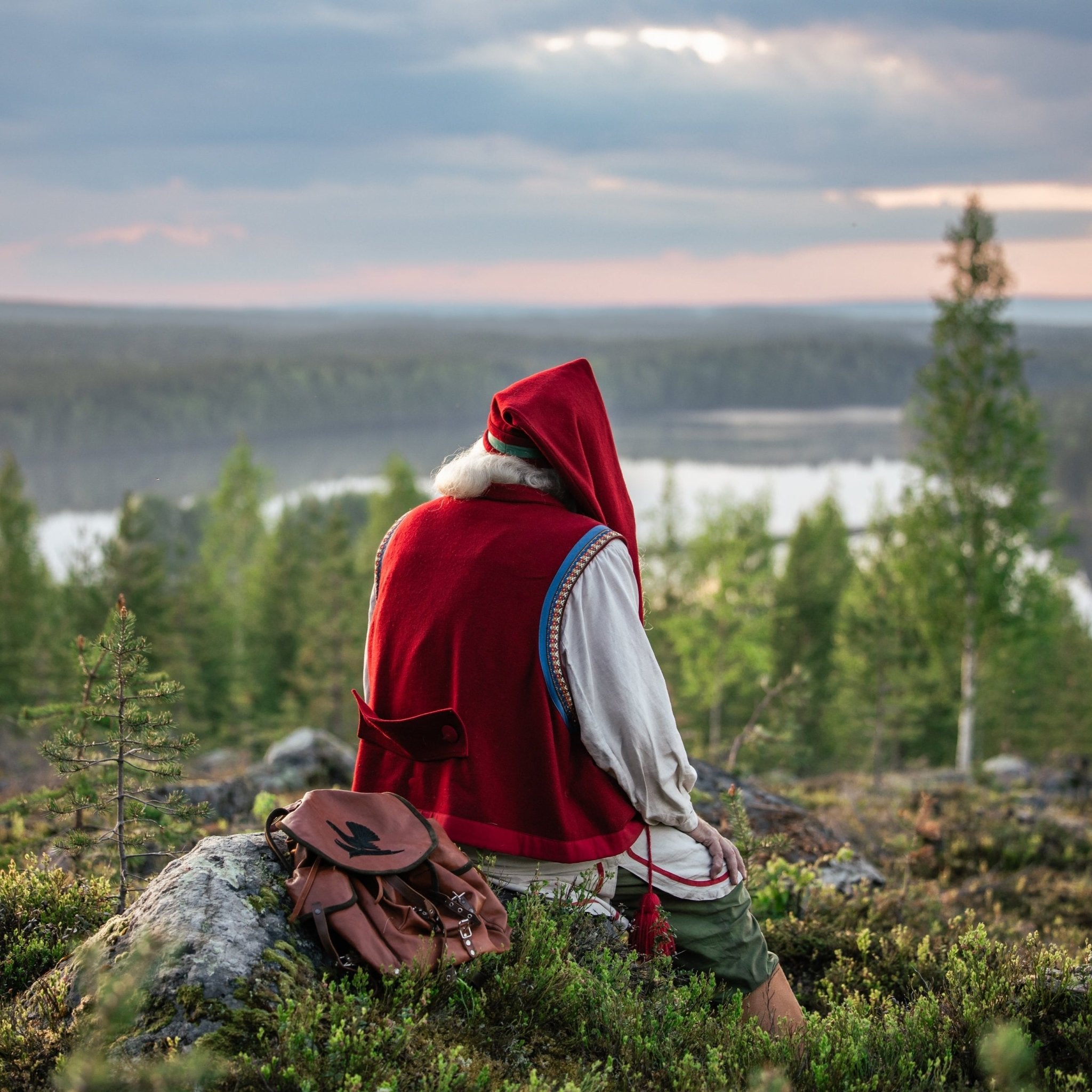 Santa Claus in traditional attire overlooking forest and river during a peaceful moment Meeting with Santa Claus Porovaara