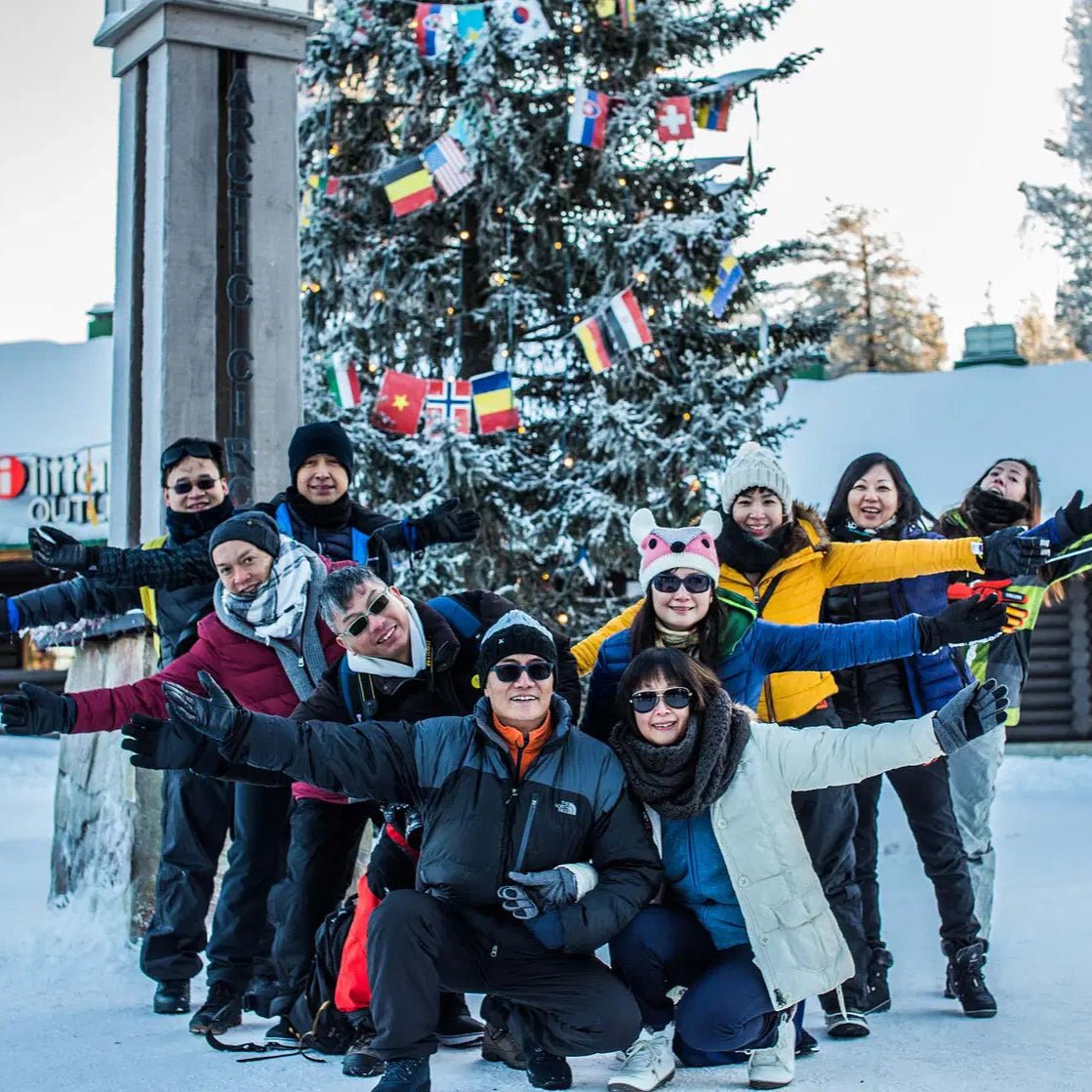 Group photo during Photoshoot in Santa Claus Village with winter clothes and flags in the background Beyond Arctic