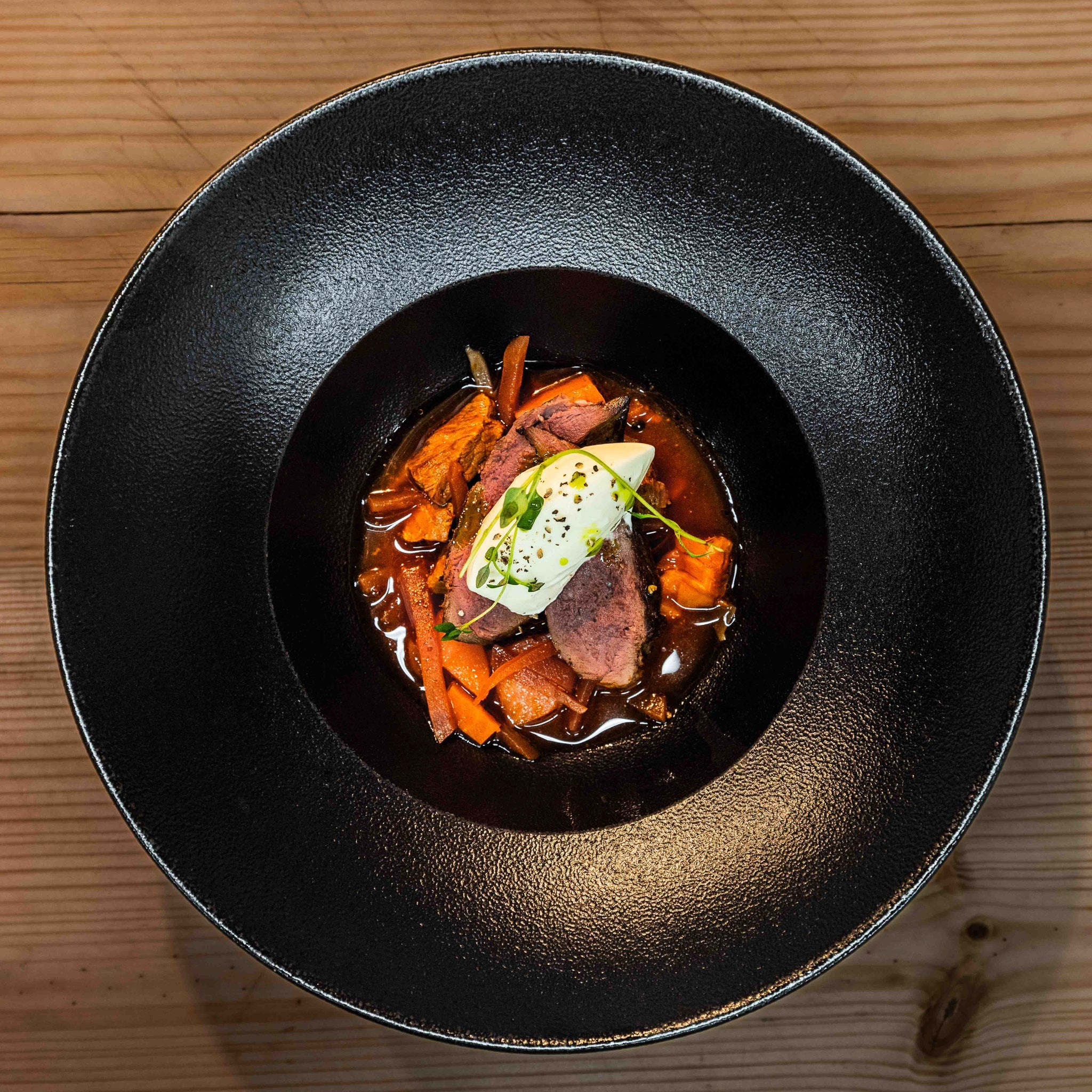 Gourmet dish with meat, vegetables, and cream sauce at Three Elves Restaurant, Santa Claus Holiday Village.