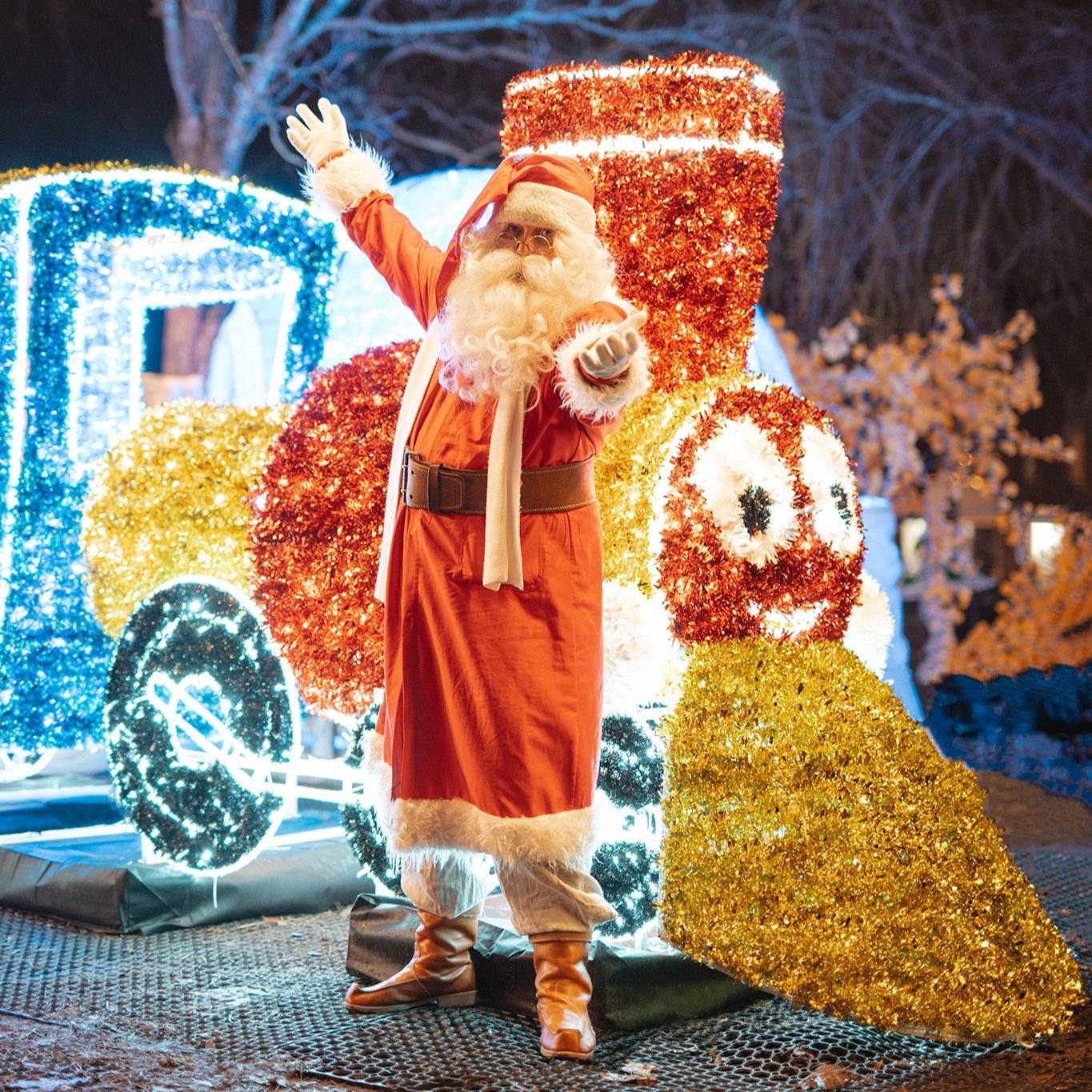 Decorative figure of a Santa Claus character with a sleigh, illuminated at night.
