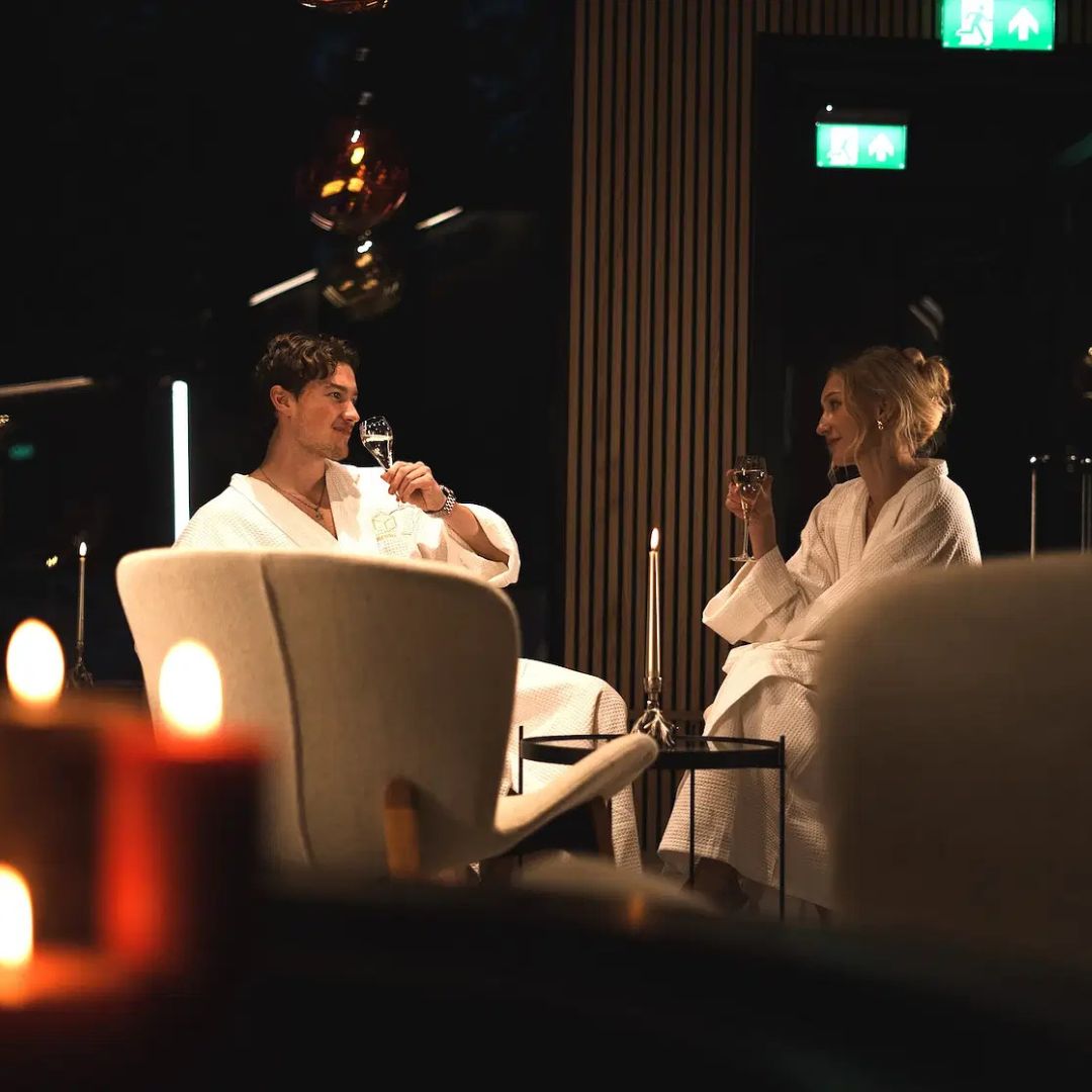 Couple in bathrobes enjoying drinks during Arctic Spa Experience with Bathrobe Dinner at Invisible Forest Lodge