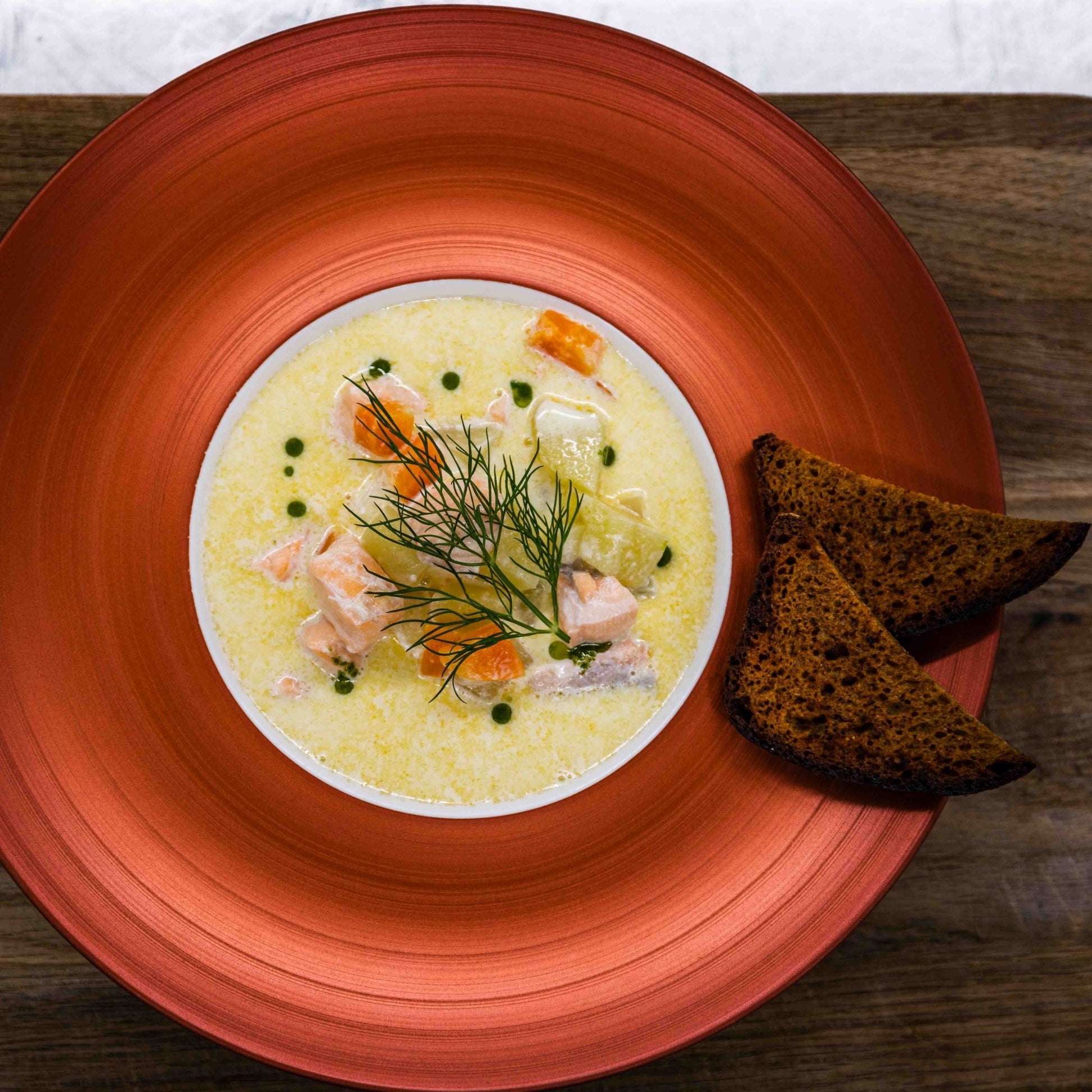 Creamy salmon soup with fresh dill and rye bread served at Christmas House Restaurant Santa Claus Holiday Village