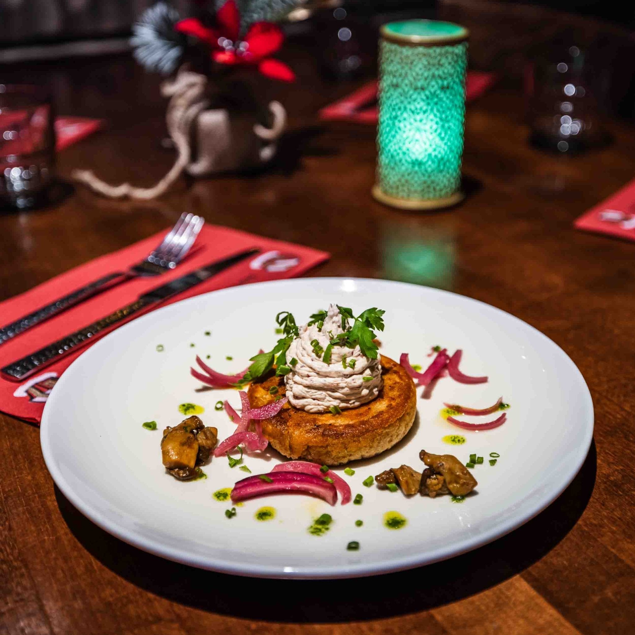Gourmet dish served at Christmas House Restaurant in a cozy festive setting by Santa Claus Holiday Village