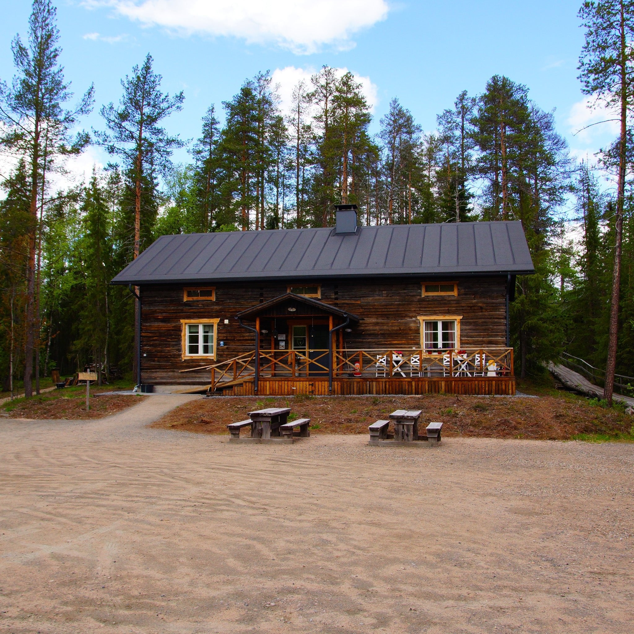 Traditional wooden cabin surrounded by forest near Auttiköngäs Falls day tour hiking by Arctic Circle Snowmobile Park