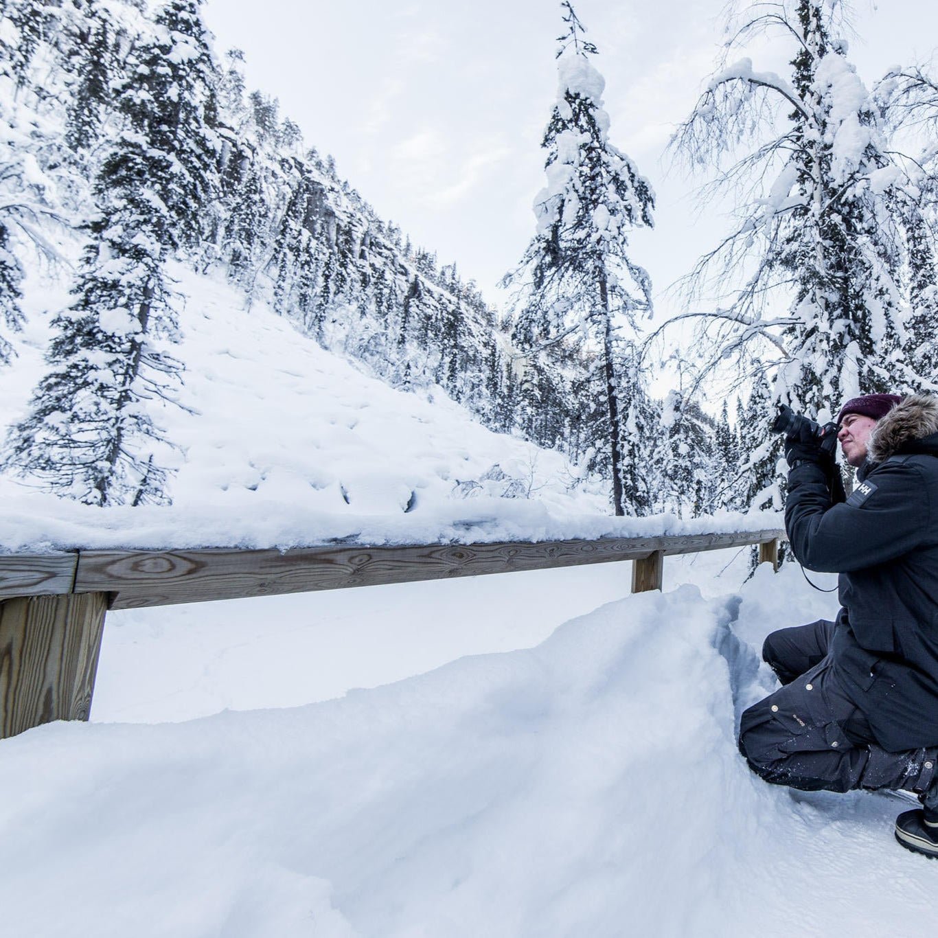 Man photographing snowy Arctic forest landscape during Korouoma Frozen Waterfalls Photography Tour by Beyond Arctic