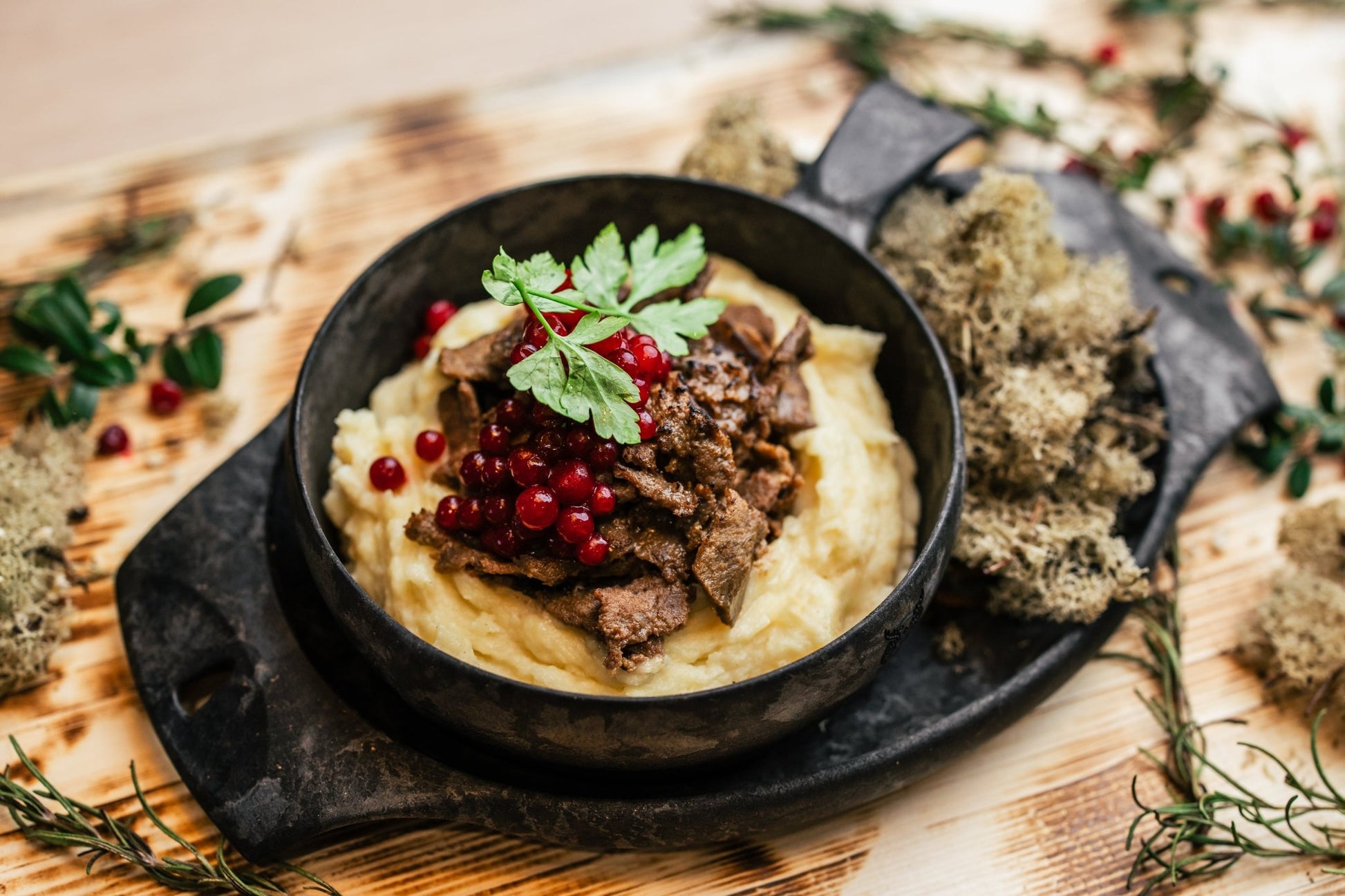 Traditional Finnish dish with mashed potatoes, reindeer meat, and lingonberries served on a rustic wooden board - Lapland Winter Park - Snow experiences