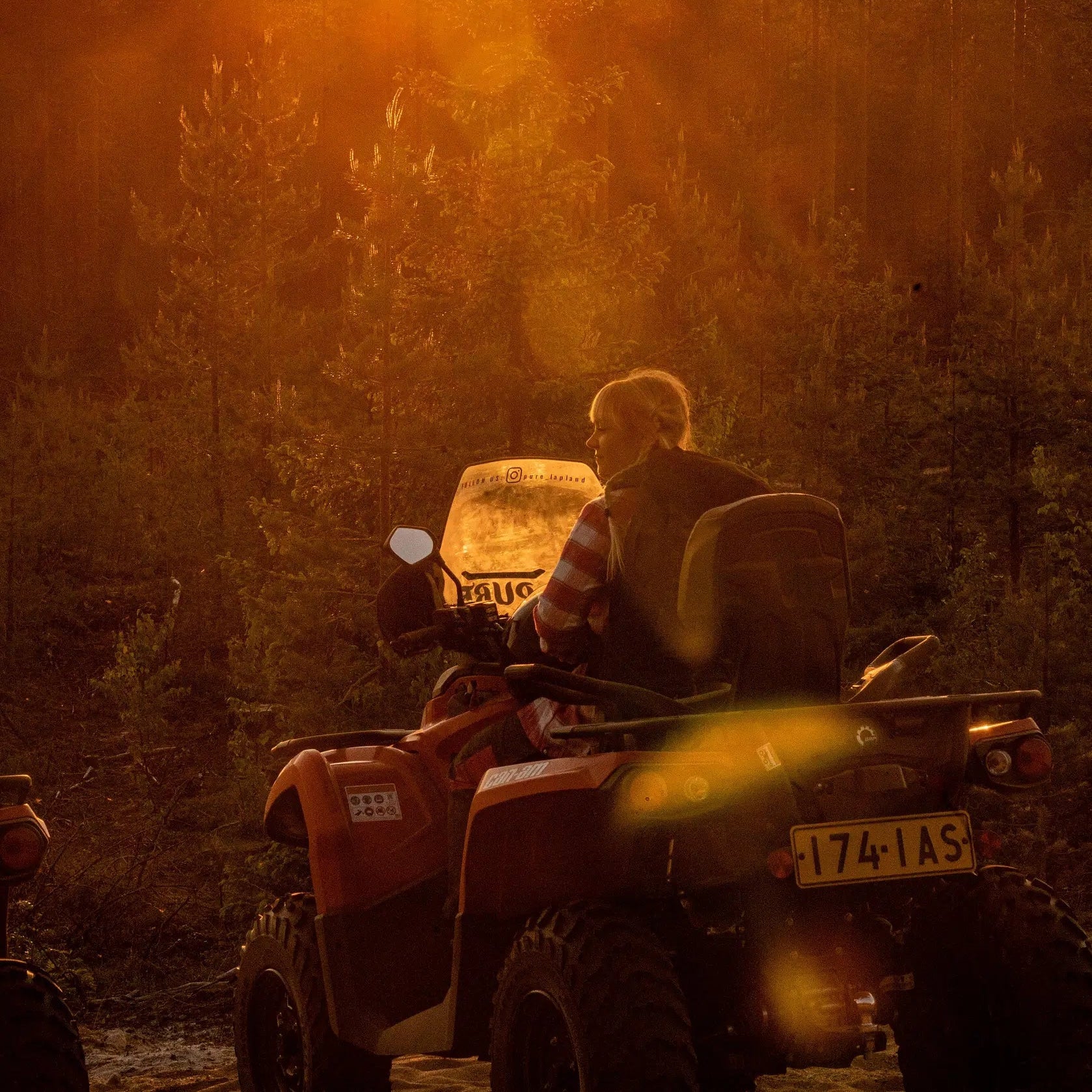Person riding a quad bike during golden hour in Arctic forest for Midnight Adventure with Quad Bikes by Pure Lapland