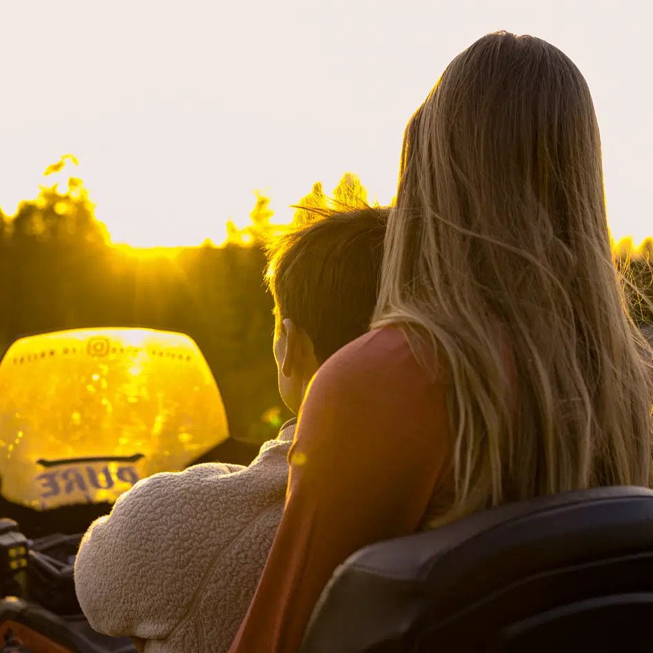 Couple enjoying a sunset ride on quad bikes during Midnight Adventure with Quad Bikes by Pure Lapland