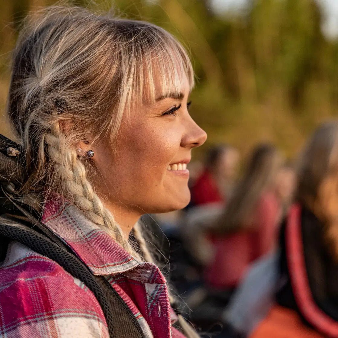 Smiling woman enjoys Arctic scenery during Midnight Adventure with Quad Bikes tour by Pure Lapland.