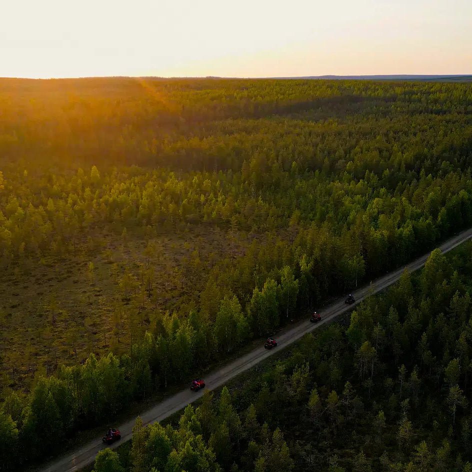 Quad bikes riding through Lapland forest at midnight sun in the Arctic adventure Midnight Adventure with Quad Bikes by Pure Lapland