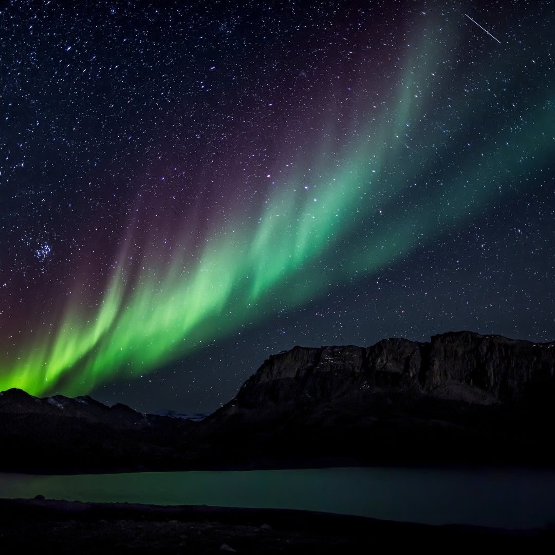 Northern Lights Alert App Rovaniemi showing vivid aurora borealis over mountains and lake by Northern Lights Alert