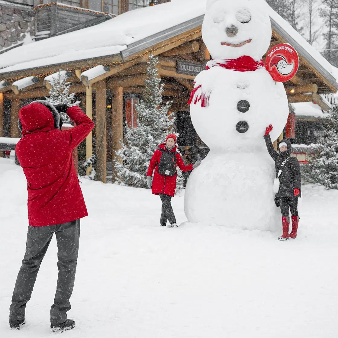 People taking photos with a giant snowman in Santa Claus Village during a winter photoshoot Beyond Arctic Photoshoot in Santa Claus Village