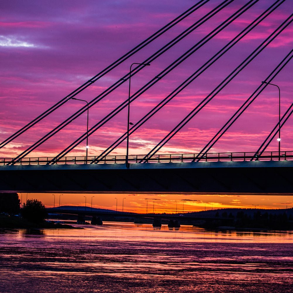 Photography tour in Rovaniemi capturing sunset over Lumberjack Bridge and cityscape by Beyond Arctic
