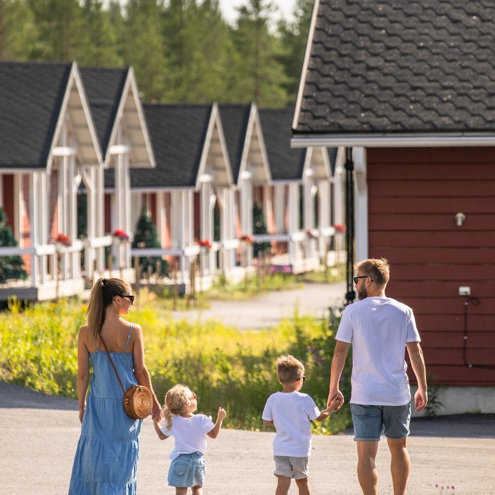 Family walking near modern cottages in Santa Claus Holiday Village, perfect for relaxing holidays – Santa Claus Holiday Village