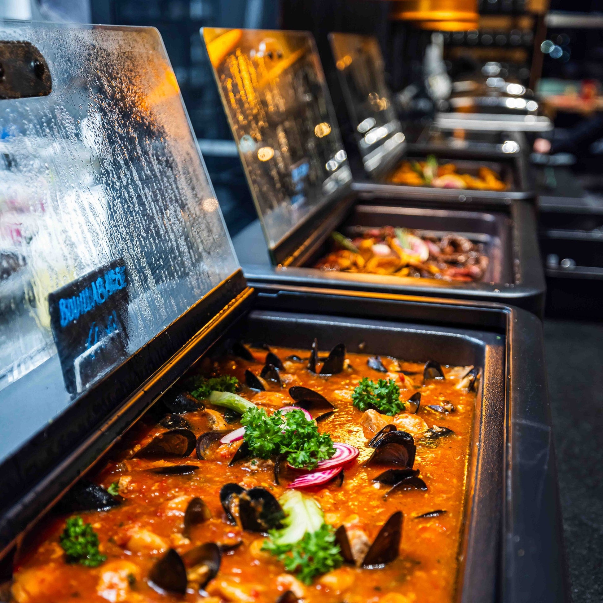 Hot buffet dishes lined up in warm serving trays at Santa's Cuisine Restaurant by Santa Claus Holiday Village