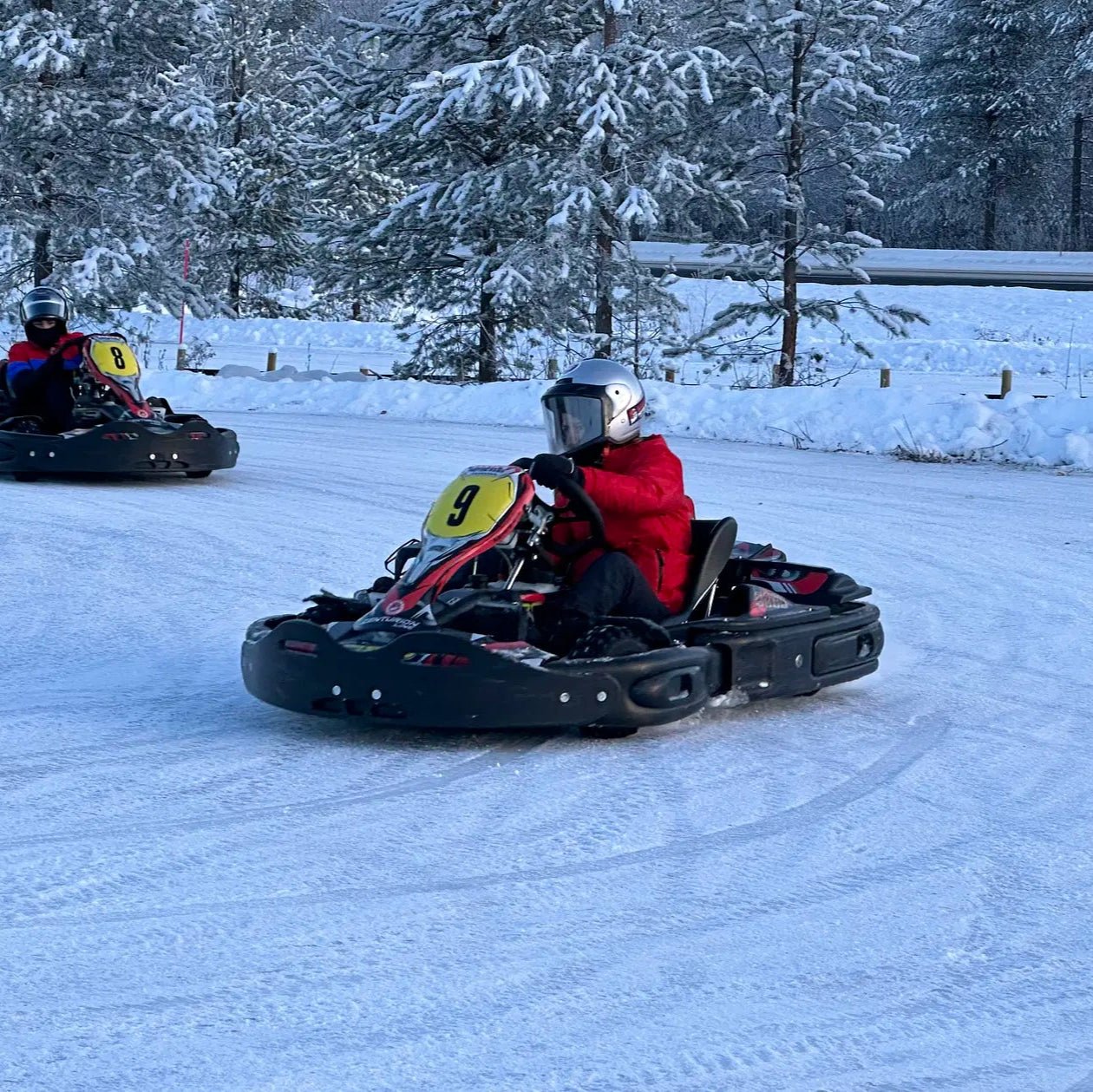 Two racers in go-karts driving on a snowy track for Santa´s Ice Karting start 16.00 by Santa's motor park