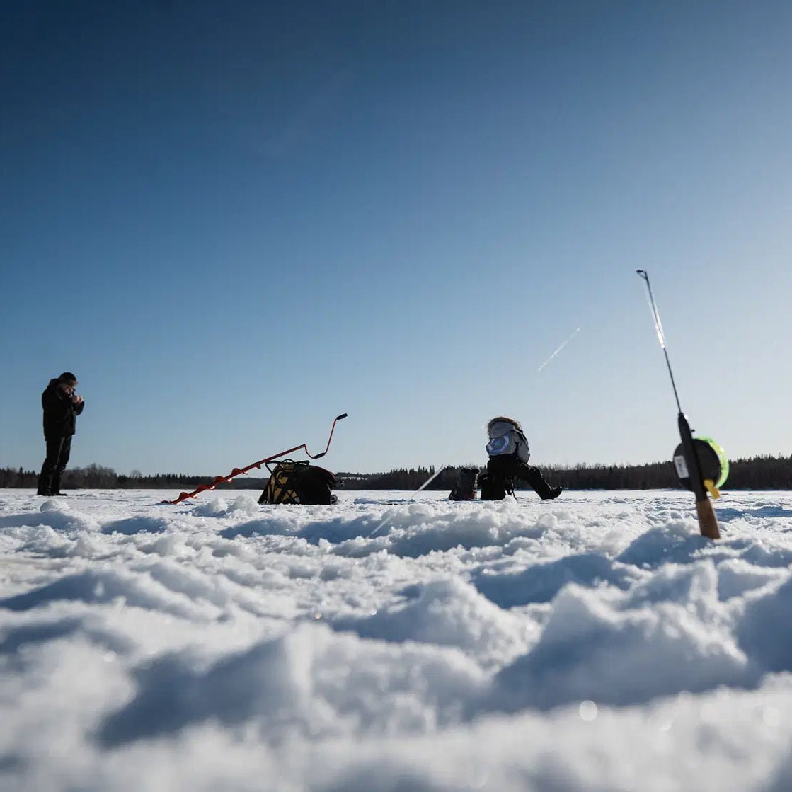 People ice fishing on a frozen lake during Skiing and Fishing on Ice Adventure by Beyond Arctic