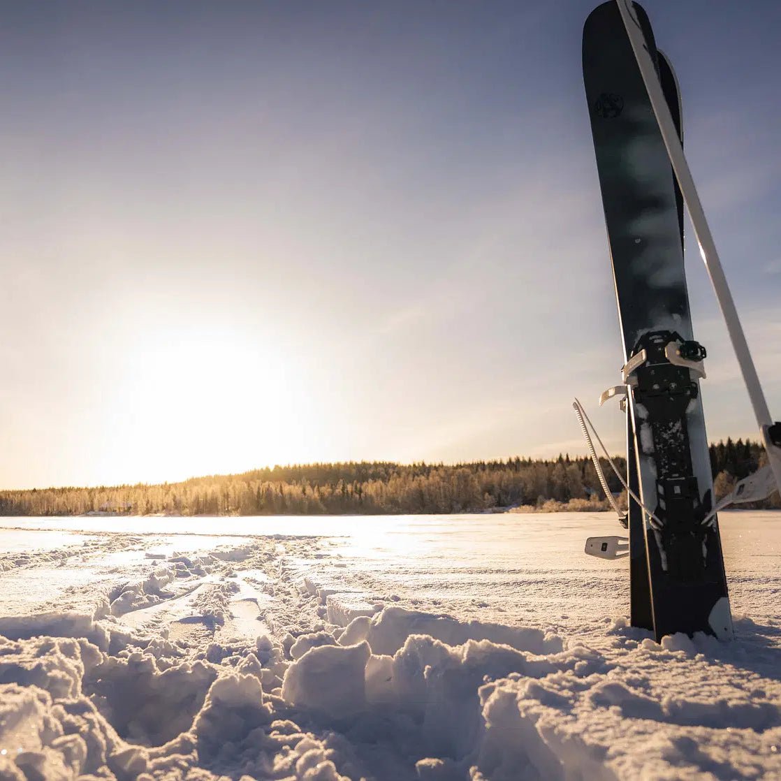 Skiing and Fishing on Ice Adventure with skis in snow at frozen lake under bright sun Beyond Arctic