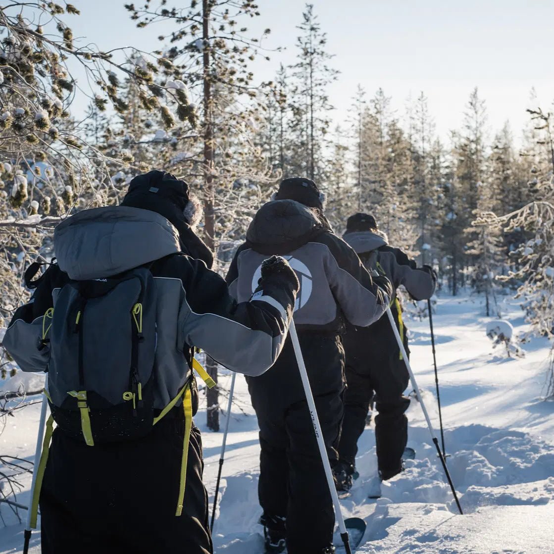 People skiing through a snowy forest during the Skiing and Fishing on Ice Adventure by Beyond Arctic
