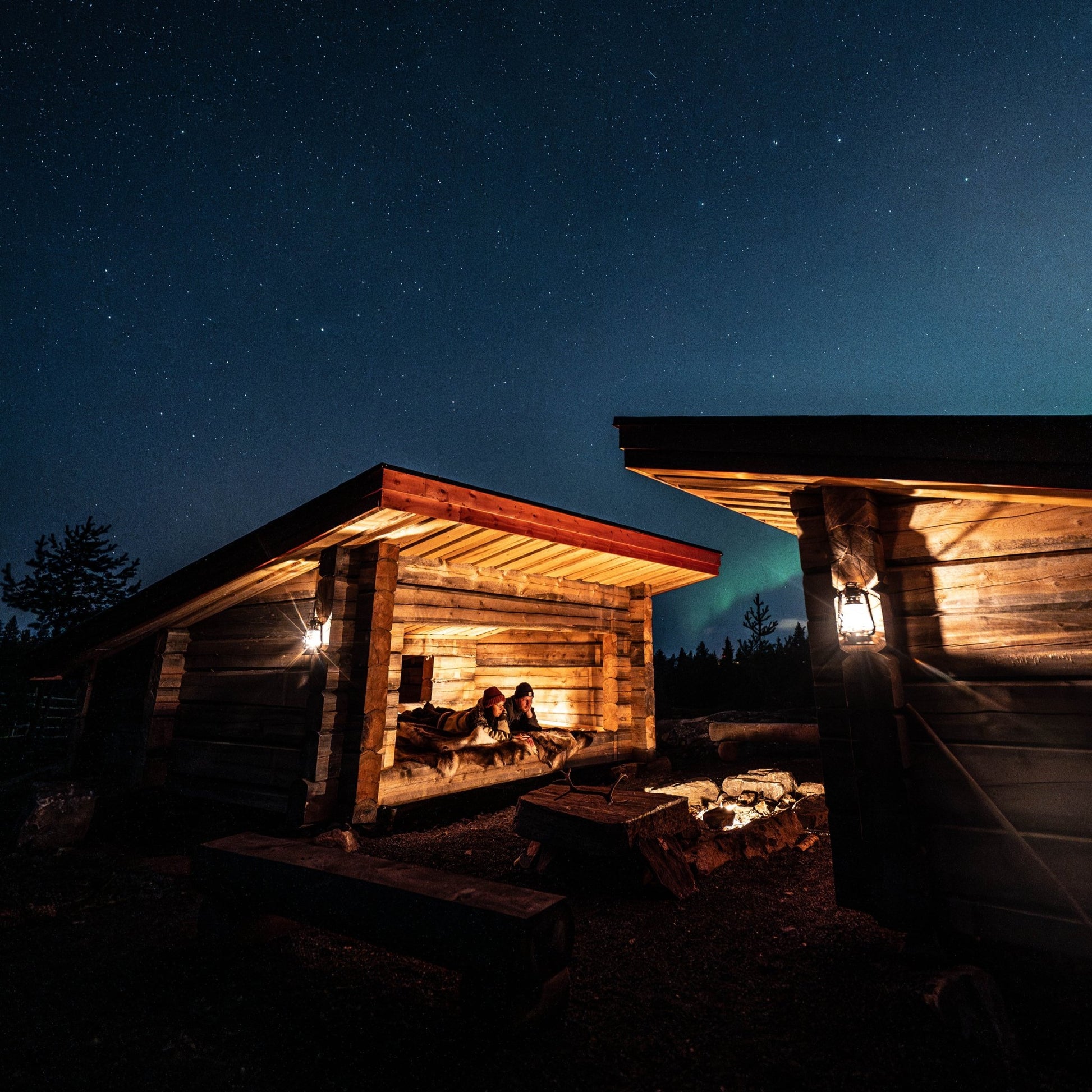 A night in the wilderness with cozy reindeer herder's lean-to under the starry Lapland sky and campfire warmth.