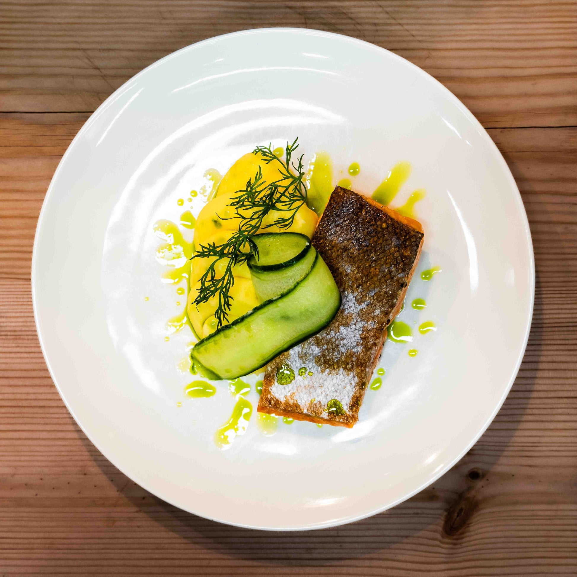 Elegant plated salmon with cucumber and mashed potatoes at Three Elves Restaurant by Santa Claus Holiday Village